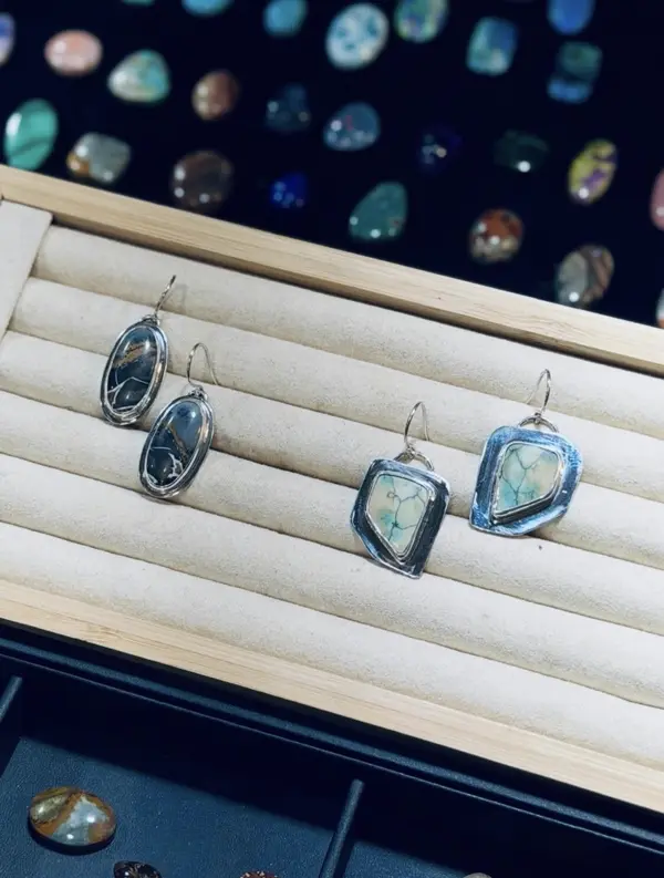 Two pairs of finished sterling earrings on a tray