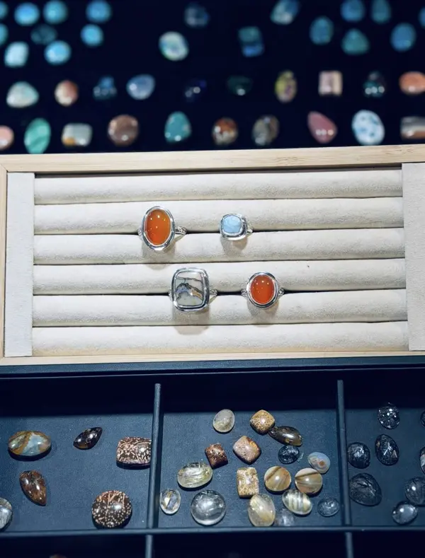 Four finished sterling rings with carnelian and blue stones