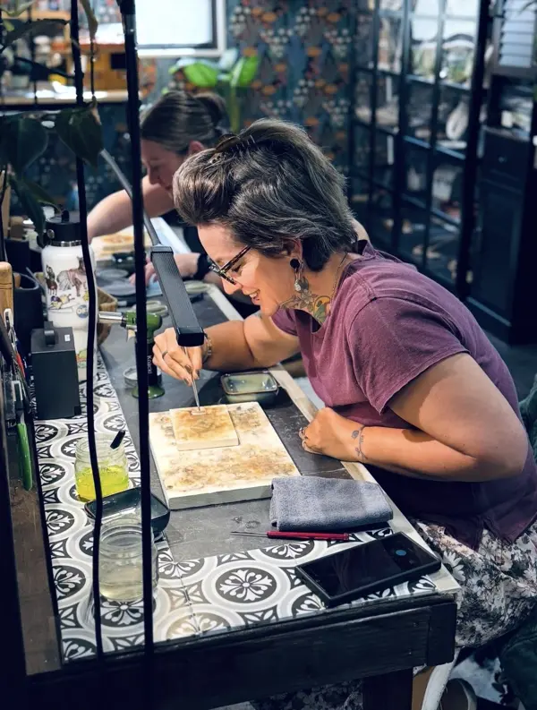 A student preparing her piece at the soldering bench